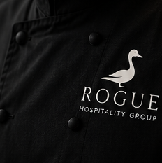 A black chef coat embroidered with the Rogue duck mark